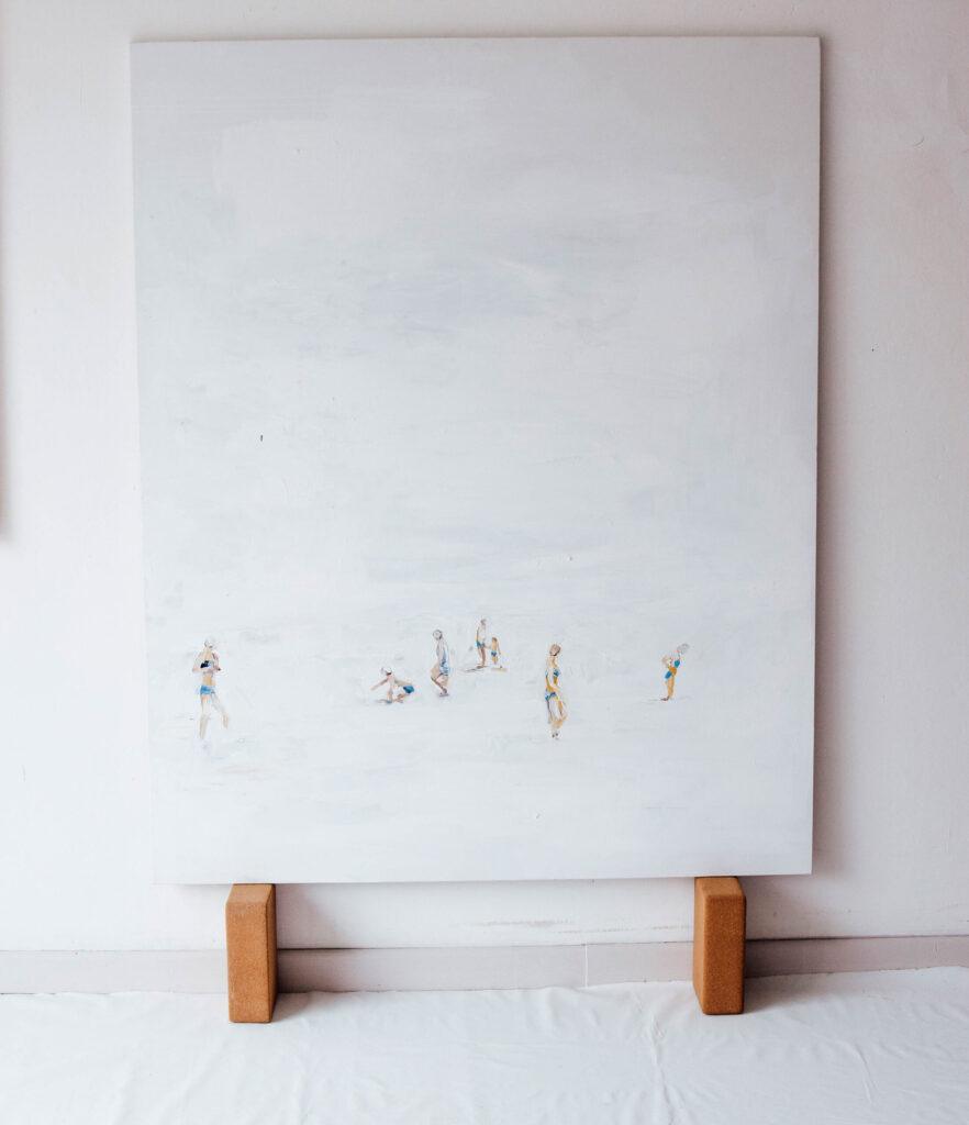 Pittura contemporanea con figura femminile in spiaggia, tonalità sabbia e azzurro, ispirata all’acqua e alla quiete.